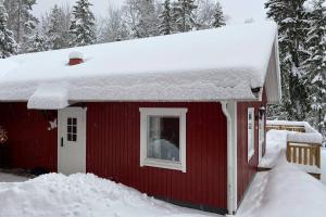 a red house with snow on the roof at Naturnära boende i vackra Järvsö - H in Järvsö