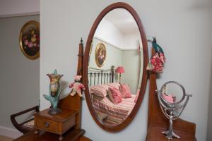 a living room with a mirror and a dresser at Chestnut Grove Bed And Breakfast in Norwich