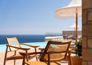 a group of chairs sitting next to a swimming pool at SOPHID Wellness Suites Karpathos in Karpathos Town