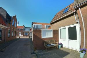 un banc installé à côté d'un bâtiment en briques dans l'établissement Zomerhuis At Sea op top locatie in Egmond aan zee, à Egmond aan Zee