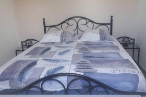 a bed with a blue and white blanket on it at Pavillon T2 proche ville dans petite résidence in Cuttoli-Corticchiato +18 photos