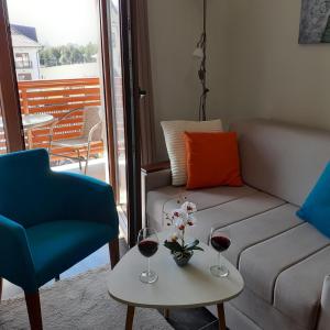 a living room with a couch and two glasses of wine at Zlatibor Hills, Top 41 in Zlatibor