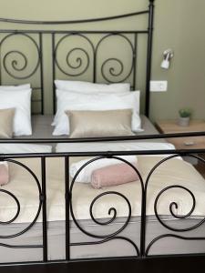 a bed with a black frame and white pillows at Rooms Lucia in Split