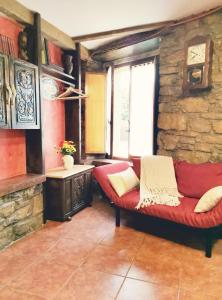 sala de estar con sofá rojo y ventana en Apartamento turístico Somió en Gijón