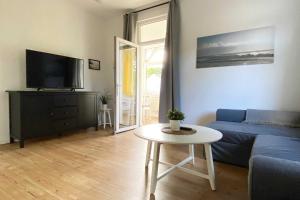 een woonkamer met een blauwe bank en een tafel bij Villa Meeresgruss FeWo 9 in Ostseebad Sellin