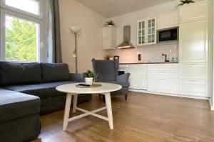 een woonkamer met een bank en een tafel bij Villa Meeresgruss FeWo 9 in Ostseebad Sellin