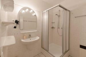 een badkamer met een douche, een wastafel en een toilet bij Villa Meeresgruss FeWo 9 in Ostseebad Sellin