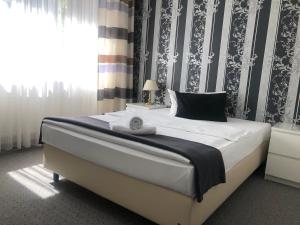 a bedroom with a large white bed with a window at Hotel Royal Hanau in Hanau am Main