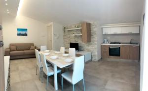 a kitchen and a dining room with a table and chairs at La Conca in San Giovanni la Punta