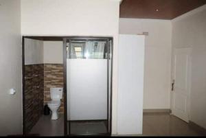 a bathroom with a toilet and a glass door at Pillacol Guest House in Victoria Falls