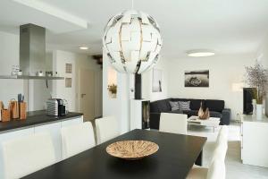 a dining room and kitchen with a black table and white chairs at Meeresvilla Lobbe in Lobbe