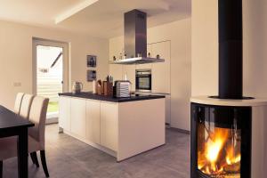 a kitchen with a fireplace in the middle of a room at Meeresvilla Lobbe in Lobbe