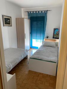 1 dormitorio con 2 camas y ventana en Apartments Gigi, en Opatija