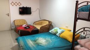 ein Schlafzimmer mit einem Bett, einem Stuhl und einem Tisch in der Unterkunft Simple Room in Mas'ada