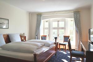 ein Schlafzimmer mit einem großen Bett und einem Fenster in der Unterkunft Hotel Alter Packhof in Hannoversch Münden