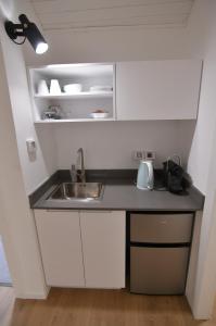 a small kitchen with a sink and a shelf at Numa Emek-Countryside Guesthouse in Yokneam Moshava in Yoqne‘am