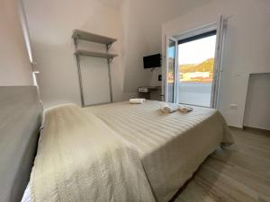 1 dormitorio con cama y ventana grande en A Pochi Passi dalla Piazza- Vista Mare en Tropea