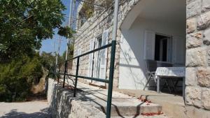 a building with a fence on the side of it at Holiday Home Odiseja in Slano