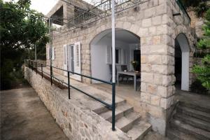 ein Steingebäude mit einer Treppe und einem Eingangsbereich in der Unterkunft Holiday Home Odiseja in Slano
