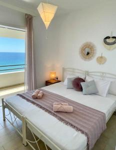 Schlafzimmer mit einem großen Bett und Meerblick in der Unterkunft Ionian Senses - Corfu, Glyfada Menigos Resort in Glyfada