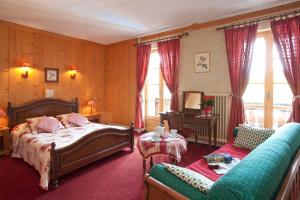 een slaapkamer met een bed en een bank bij Hotel Christiania in Villard-de-Lans