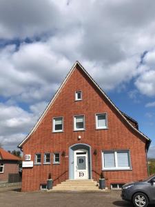 een rood bakstenen gebouw met een witte deur bij Diepholzer–Boardinghouse in Diepholz