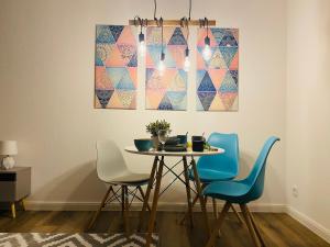 a dining room table with blue chairs and a painting at See Apart 3 in Öhningen