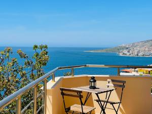 balcone con tavolo, sedie e vista sull'oceano di JB Apartments a Sarandë