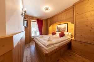 a bedroom with a bed in a room with wooden walls at Cadin Apartment in Cortina dʼAmpezzo
