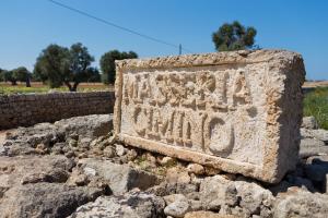 a stone sign sitting on some rocks at Masseria Cimino in Savelletri di Fasano