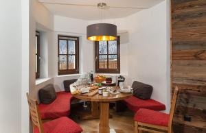 a dining room with a wooden table and red chairs at Haus Gertrud in Sankt Anton am Arlberg +70 photos