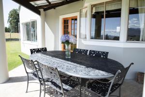a black table with chairs and a vase of flowers at Dragons Landing Guest Farm in Underberg