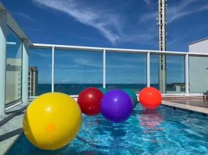 a group of colorful balls in a swimming pool at Marina Bezerril - Cobertura Lemon Flat - A melhor de Ponta Negra in Natal