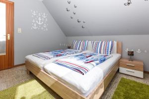 ein Schlafzimmer mit einem Bett mit gestreiften Kissen darauf in der Unterkunft Ferienwohnungen Wind & Meer in Neuharlingersiel