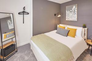 a bedroom with a large bed and a mirror at Host & Stay - The Waves in Whitby