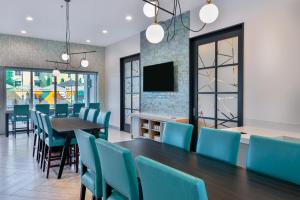 Hyatt House Tampa Airport/Westshore في تامبا: غرفة طعام مع طاولة وكراسي زرقاء