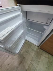 an empty refrigerator with its door open in a kitchen at Light room Затока in Zatoka
