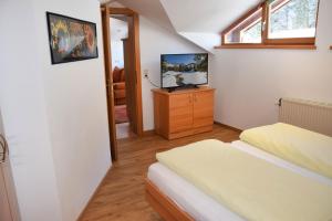 a small bedroom with a bed and a television at Aparthotel Lieblingsplatz in Filzmoos