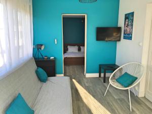 um quarto azul com uma cama e uma cadeira em Vacances Sur Mer em Saint-Palais-sur-Mer