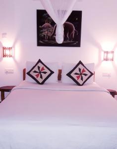 ein Schlafzimmer mit einem weißen Bett mit zwei Kissen in der Unterkunft Ella Secret Paradise in Ella
