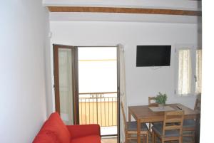 a living room with a dining room table and a television at LE DIMORE DI DAMAROPE' in Agrigento