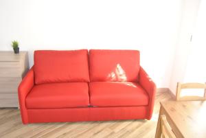 LE DIMORE DI DAMAROPE' في أغريغينتو: وجود أريكة حمراء في غرفة المعيشة