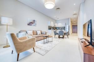 a living room with a couch and a tv at SOL Living - SOL Avenue in Dubai