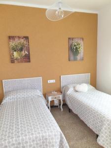 a bedroom with two beds and two pictures on the wall at Casa Pepe de L´ullat in Deltebre +23 photos