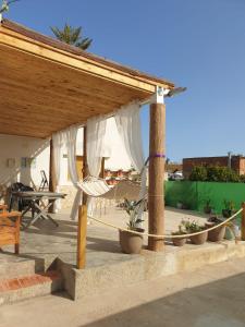einen Pavillon mit einem Tisch, Stühlen und Topfpflanzen in der Unterkunft Casa Pepe de L´ullat in Deltebre