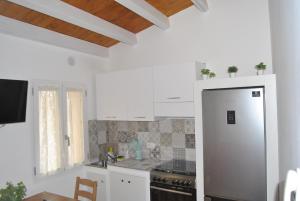 una cucina con armadi bianchi e frigorifero in acciaio inossidabile di LE DIMORE DI DAMAROPE' a Agrigento