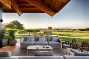 a living room with a couch and chairs on a patio at Empordà Golf Resort in Torroella de Montgrí