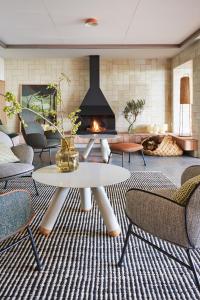 a living room with a fireplace and a table and chairs at Empordà Golf Resort in Torroella de Montgrí