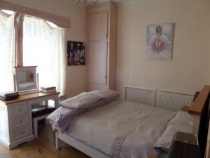 1 dormitorio con cama, escritorio y ventana en Jane's Cottage Free Parking, en Inverness