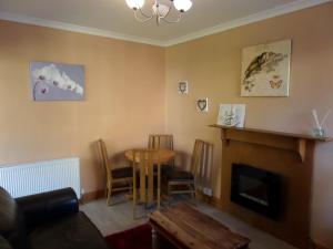 sala de estar con mesa y chimenea en Jane's Cottage Free Parking, en Inverness